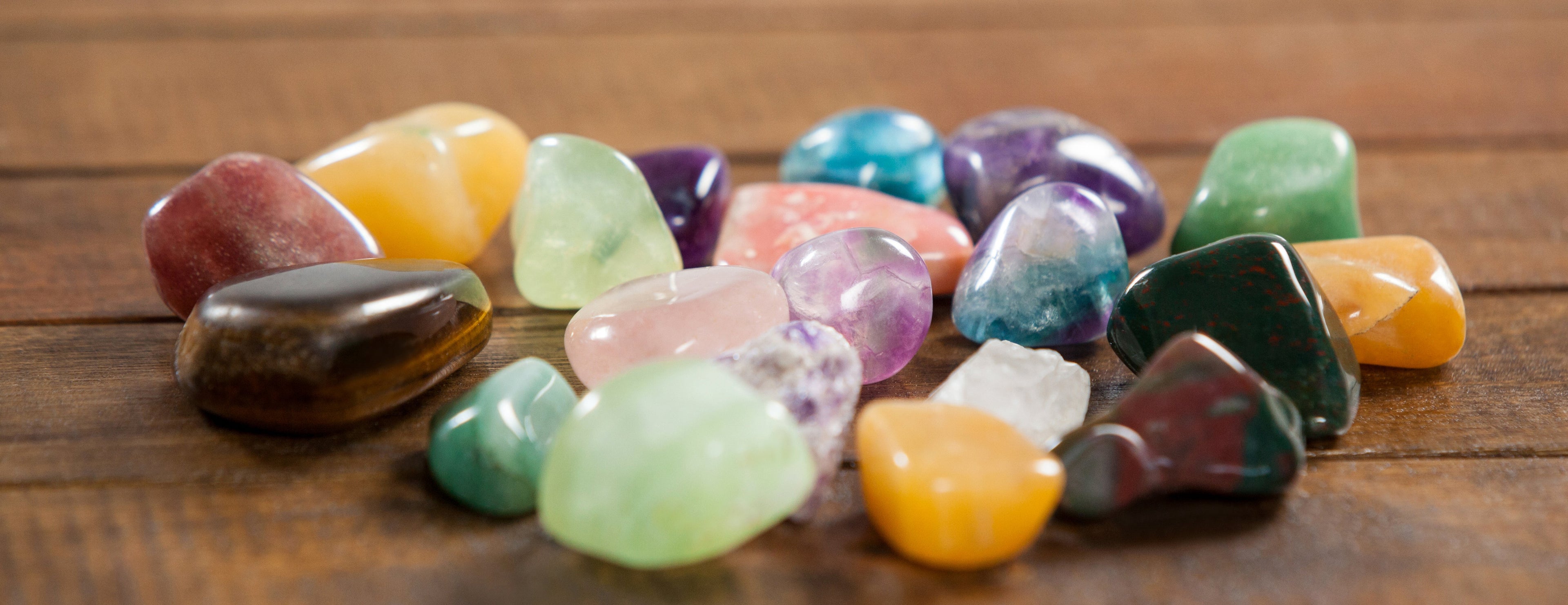 Groupes de pierres semi‑précieuses variées disposées sur une table.
