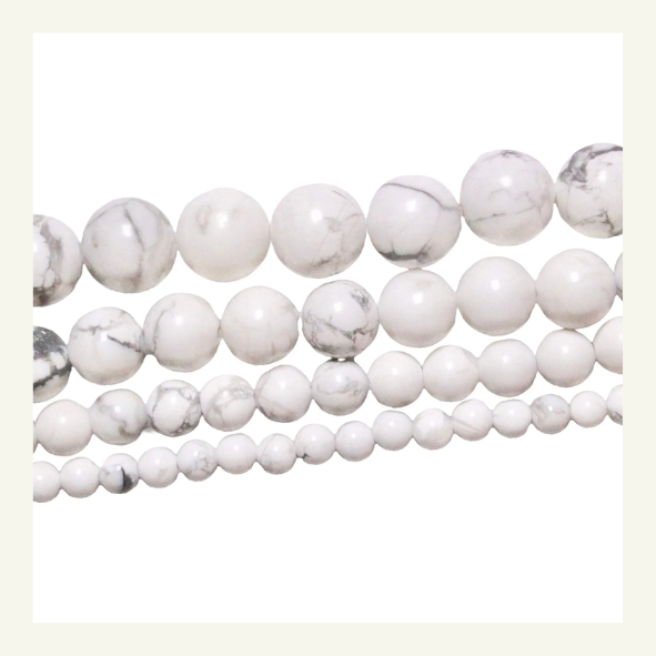 Perle de Howlite, pierre blanche marbrée de gris, utilisée pour son aspect apaisant et sa beauté.