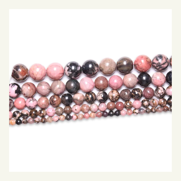 Perle de rhodonite, pierre rose avec des inclusions noires, symbole d'amour et de guérison émotionnelle.