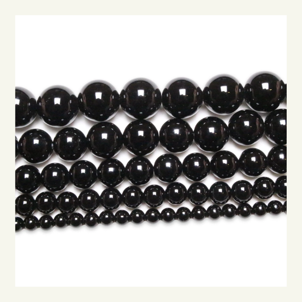Perle de tourmaline noire, pierre opaque d'un noir profond, connue pour ses vertus de protection énergétique.
